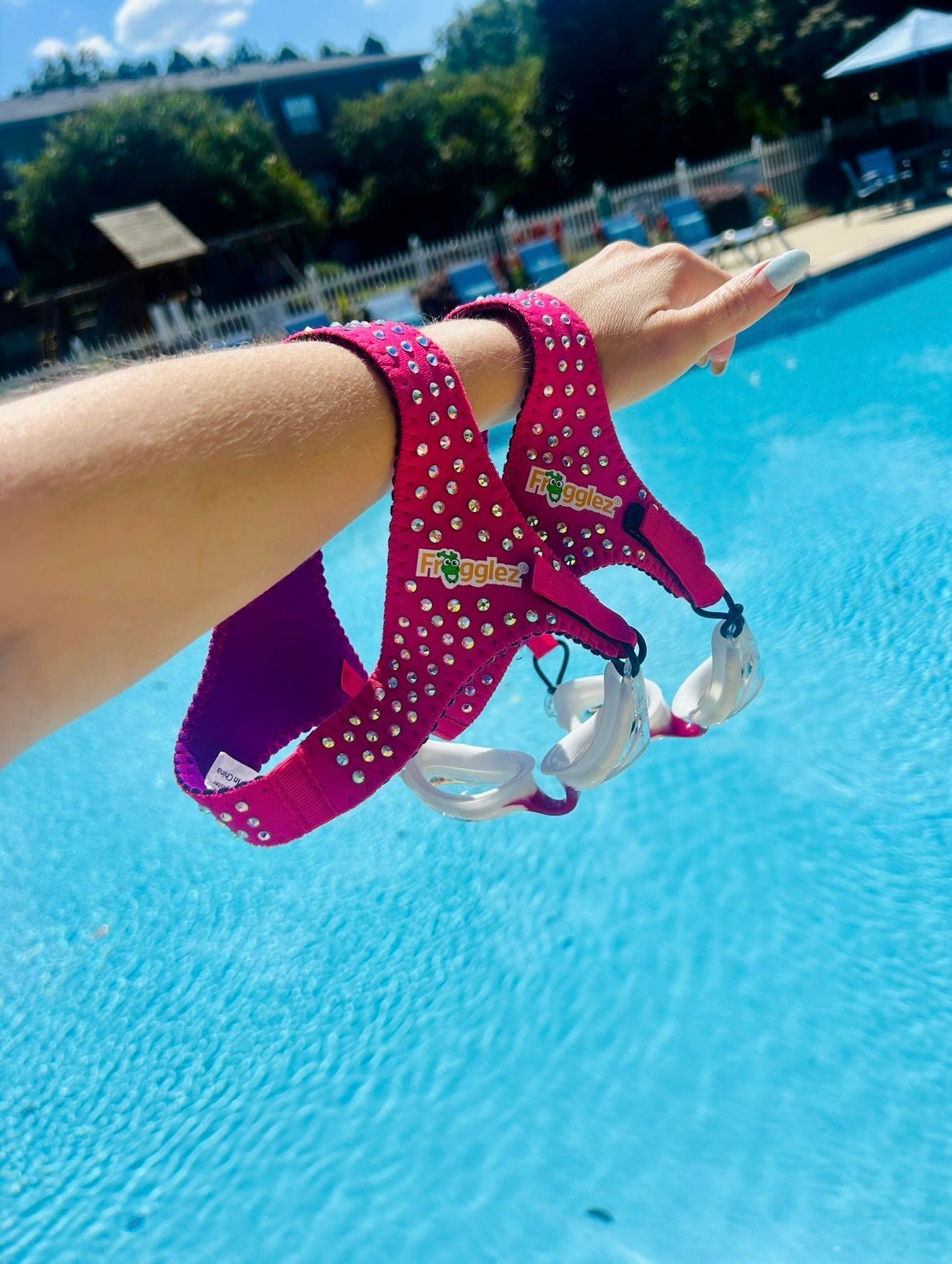 Kids goggles fits ages 3-10. Pictured girl wearing pink frogglez goggles at water park and boy swimming underwater with green frogglez goggles. 